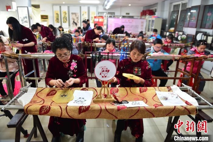 江西省級非遺豫章繡傳承人手把手指導(dǎo)小學(xué)生繡制2022年北京冬奧會吉祥物“冰墩墩”形象?！∮髟屏?攝