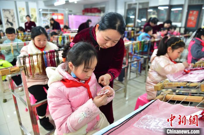 江西省級非遺豫章繡傳承人手把手指導(dǎo)小學(xué)生繡制2022年北京冬奧會吉祥物“冰墩墩”形象?！∮髟屏?攝