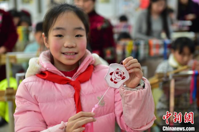 圖為一名小學(xué)生繡制的2022年北京冬奧會吉祥物“冰墩墩”形象?！∮髟屏?攝