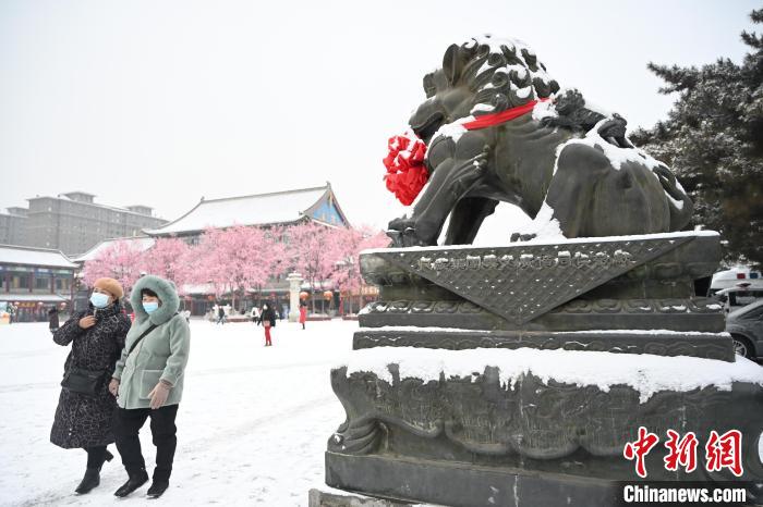 2月13日，民眾在呼和浩特市大召廣場雪中漫步?！⑽娜A 攝