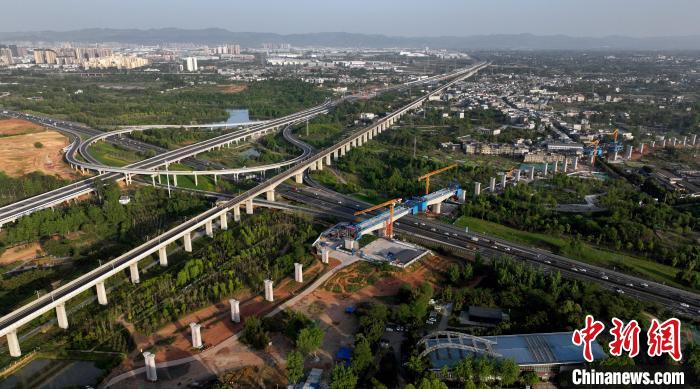 航拍正在建設(shè)的跨越成都繞城高速公路連續(xù)梁施工現(xiàn)場，旁邊依次為已運營的成渝高速鐵路和機場高速公路?！⒅铱?攝
