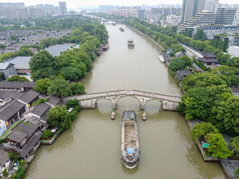 5月27日，一艘貨船駛過京杭大運(yùn)河南端標(biāo)志建筑杭州拱宸橋。(無人機(jī)照片)新華社記者江漢 攝