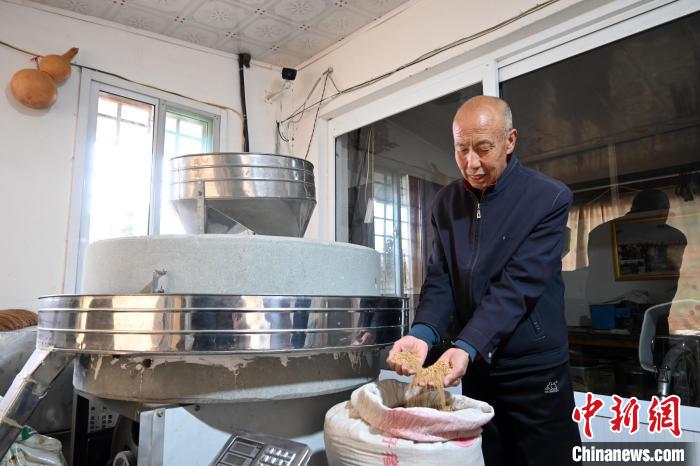 李家莊村民谷文朝重拾父輩的手藝，做起石磨面粉的營生?！〉杂鸺?攝