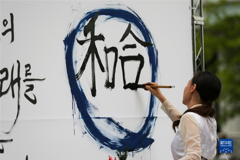 5月30日，在韓國首爾舉辦的“中日韓合作之日”慶?；顒?dòng)中，表演者進(jìn)行中日韓精神——2023年度漢字“和合”書法表演。新華社記者 王益亮 攝
