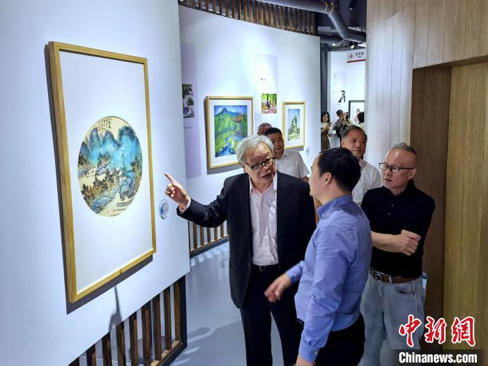 海峽兩岸藝術(shù)家畫展上，藝術(shù)家進(jìn)行藝術(shù)交流?！「毒窜?攝