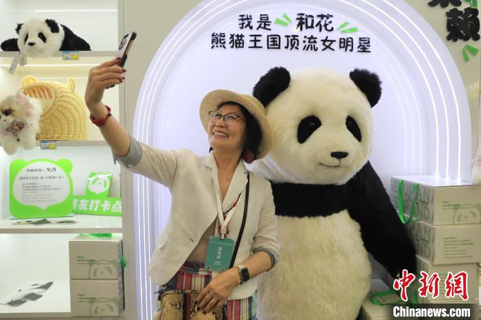 美國華視總裁楊蓮花與大熊貓文創(chuàng)產(chǎn)品合影?！⊥趵?攝