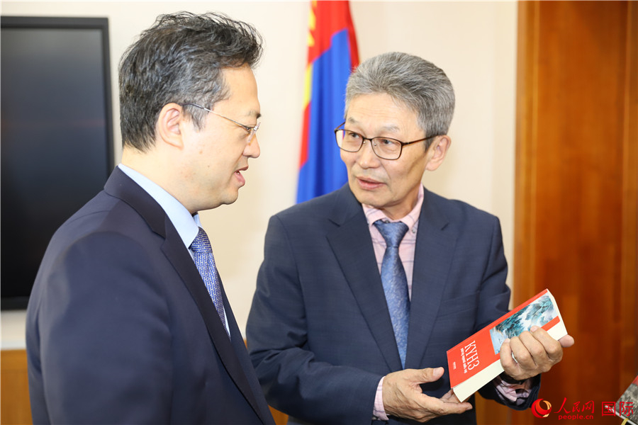 其米德策耶（右一）向李峙介紹翻譯成果。人民網記者 霍文攝