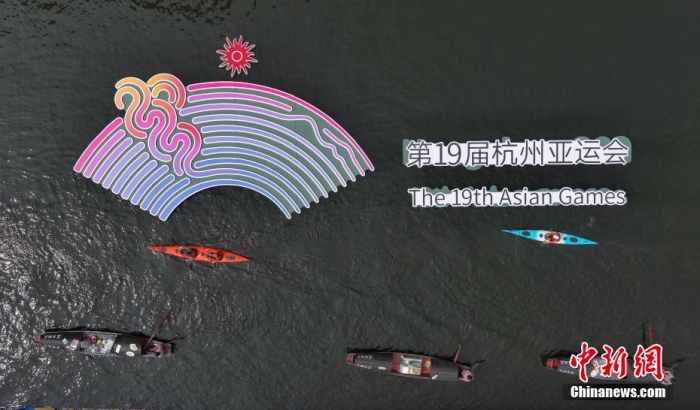 資料圖為烏篷船和皮劃艇從杭州亞運(yùn)會(huì)標(biāo)識(shí)前劃過(guò)。王剛 攝