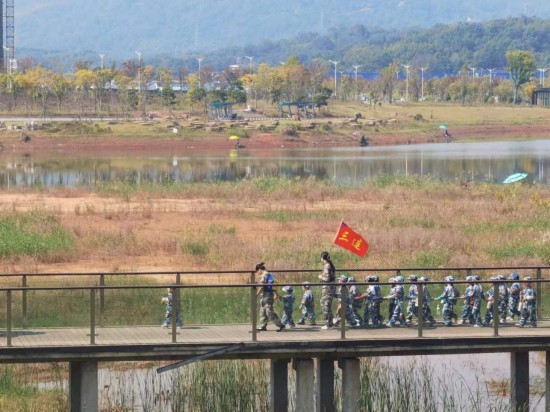 　　10月24日，秋游的幼兒園小朋友在老師帶領(lǐng)下走在清水塘公園里的木橋上。本報記者 常雯宜攝
