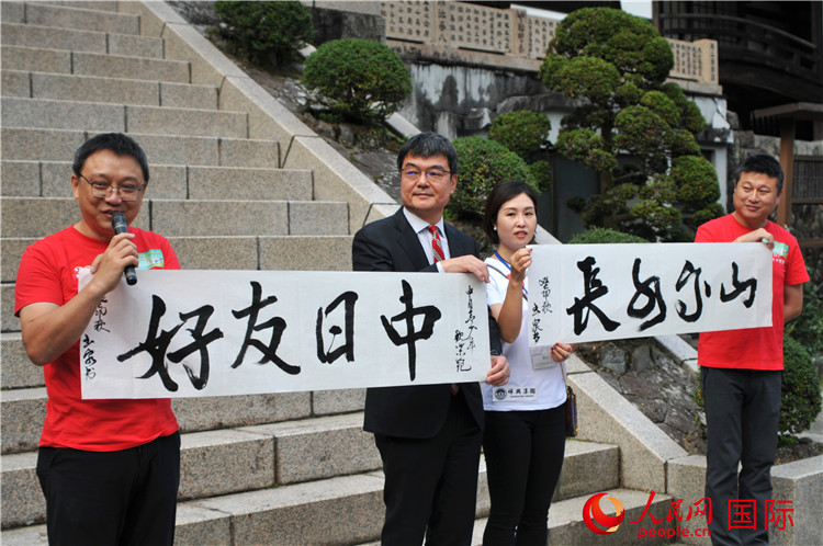東京中國文化中心主任羅玉泉展示其為本次活動書寫的題詞“中日友好，山高水長”。人民網(wǎng) 蔣曉辰攝