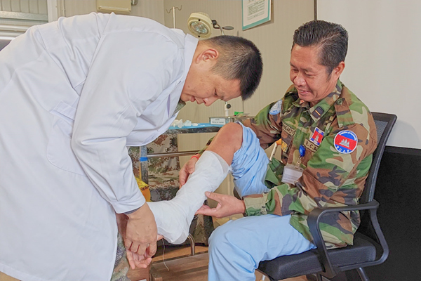 中國第22批赴黎維和醫(yī)療分隊軍醫(yī)為患者打石膏固定患肢。李清竹攝