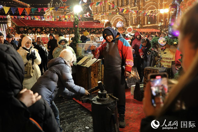 游客在新年集市上體驗(yàn)制作紀(jì)念幣。人民網(wǎng)記者 隋鑫攝