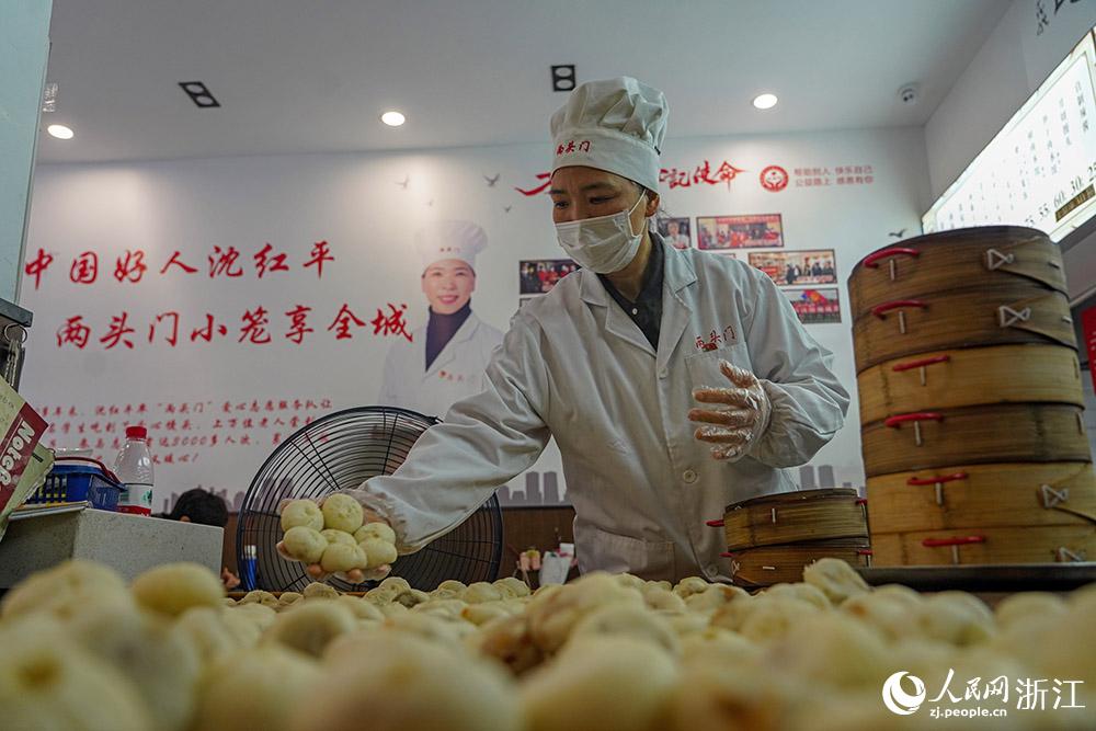 3月31日，在浙江省嵊州市甘霖鎮(zhèn)，嵊州小吃從業(yè)者沈紅平把蒸熟的小籠包晾涼，打包冷藏售賣。人民網(wǎng) 章勇濤攝