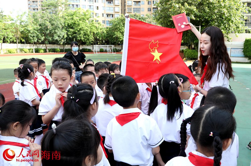 老師向少先隊員展示隊旗。人民網(wǎng) 符武平攝