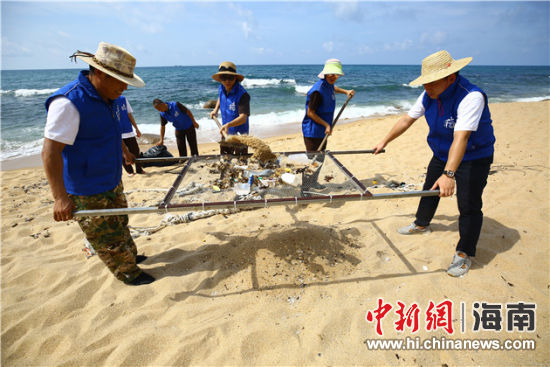 環(huán)保志愿者用篩網(wǎng)“淘”出海灘上的垃圾。
