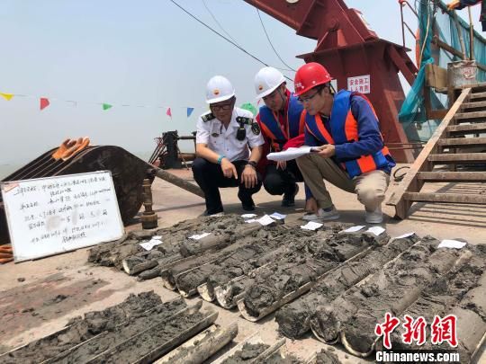 圖為勘察設(shè)計(jì)人員與海事局工作人員查看巖芯情況?！∥赫?攝