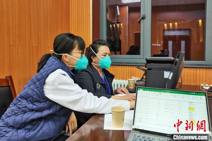 8月9日，楊蘇喬(左)在拉薩方艙醫(yī)院指揮部讀取艙內(nèi)患者胸部CT?！∈茉L者供圖