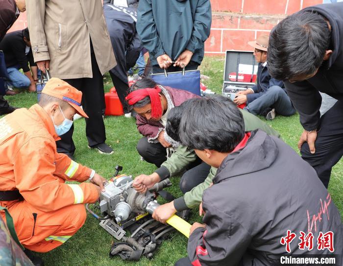 圖為森林消防員為護(hù)林員講解滅火裝備的使用方法。　昌都市森林消防支隊 供圖