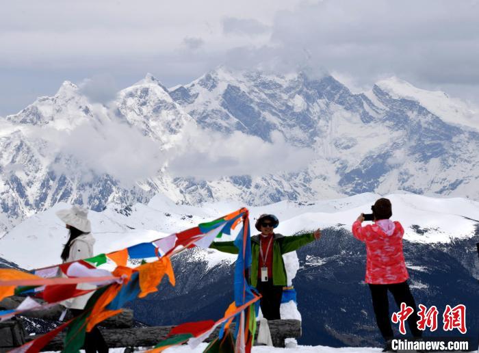 圖為5月14日，西藏林芝色季拉山觀景臺，游客與南迦巴瓦峰合影。　李林 攝