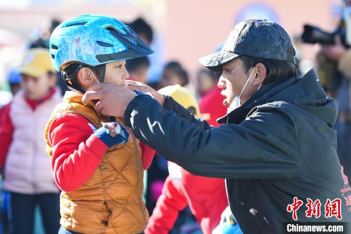 圖為拉薩市實驗幼兒園孩子在教練的幫助下穿戴頭盔?！『闻罾?攝