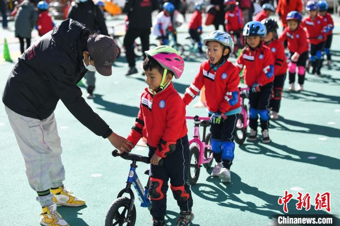 圖為拉薩市實驗幼兒園孩子們在教練的指導(dǎo)下練習(xí)滑步車?！『闻罾?攝