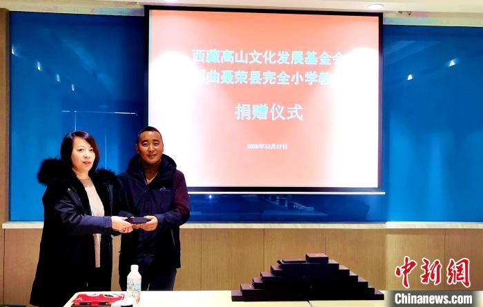 圖為西藏高山文化發(fā)展基金會(huì)理事長(zhǎng)溫麗向聶榮縣完全小學(xué)負(fù)責(zé)人捐助儀器。　于賓 攝