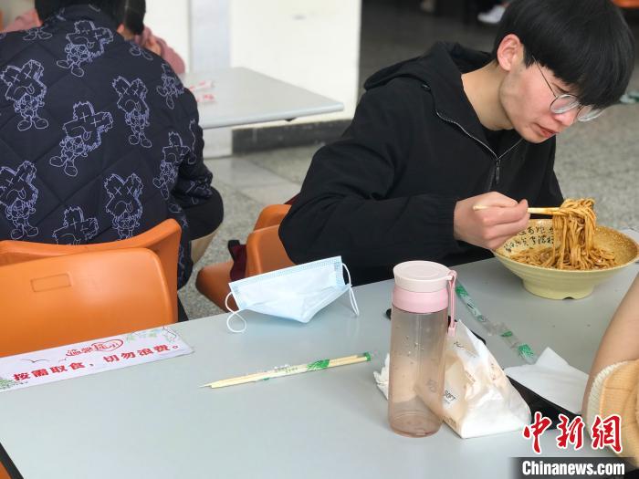3月17日，西藏大學學生正在學校食堂用餐，餐桌上寫著“按需取餐，切勿浪費”。　冉文娟 攝