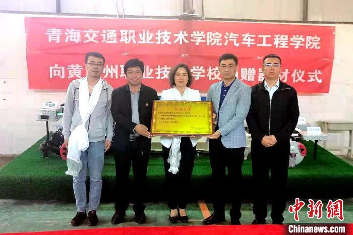 圖為李富香(中)代表學(xué)校為州縣技校捐贈器材。(資料圖) 青海省教育廳供圖