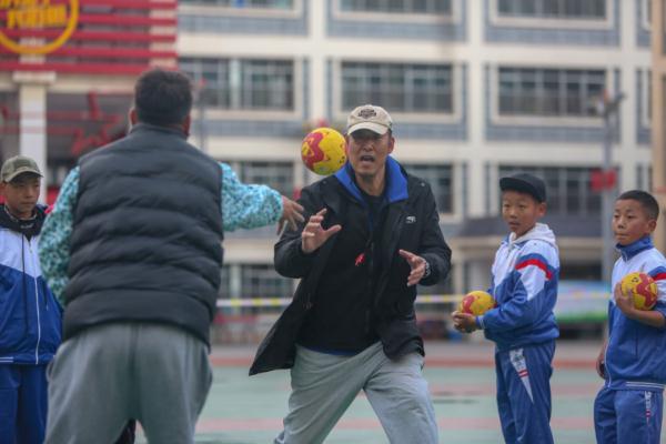 在高原上教孩子們打手球，“慢慢兒來，甭著急！”