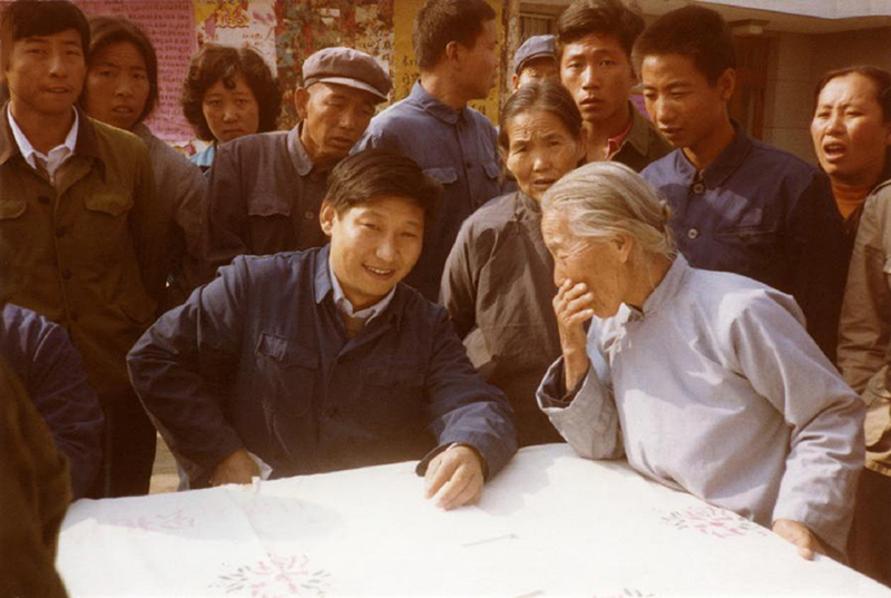 1983年，時(shí)任河北正定縣委書記的習(xí)近平（前排居中），臨時(shí)在大街上擺桌子聽取老百姓意見。