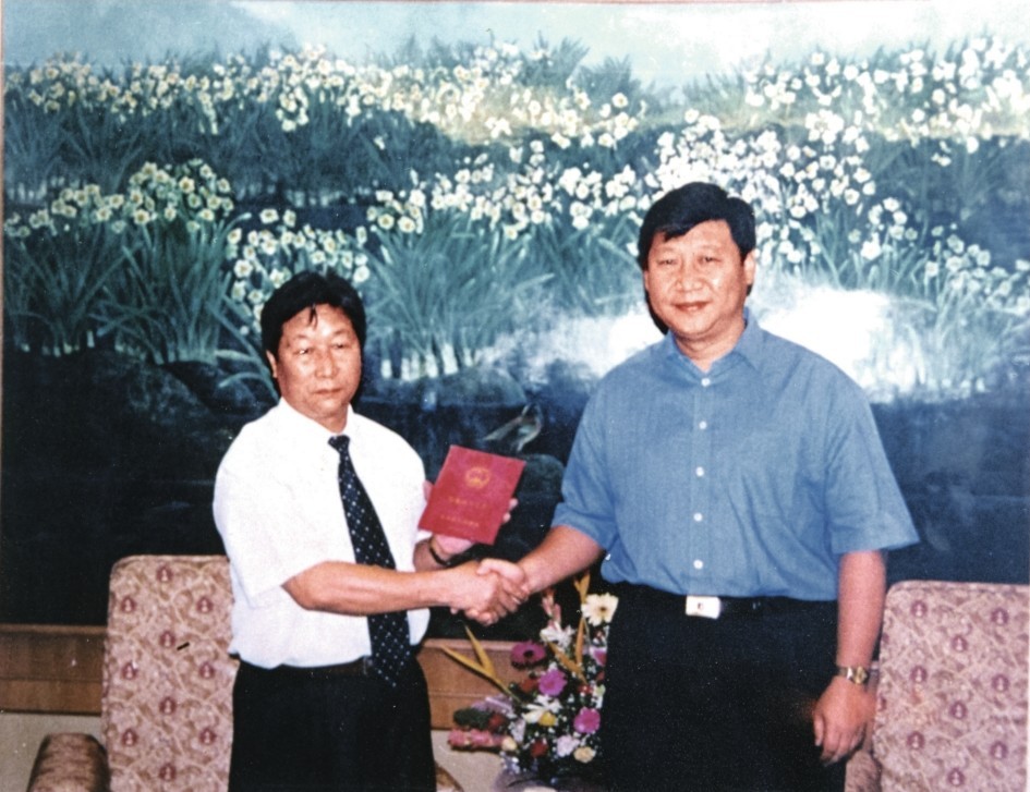 2000年7月，習近平為福建農(nóng)林大學教授林占熺頒發(fā)福建省政府“一等功”榮譽證書。圖源：《習近平在福建》（下）