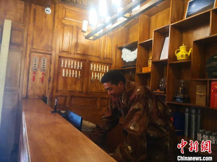 圖為桑杰才讓用電腦處理財(cái)務(wù)?！∈缝o靜 攝
