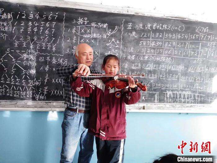 圖為趙興洲教學(xué)生拉小提琴。受訪者提供