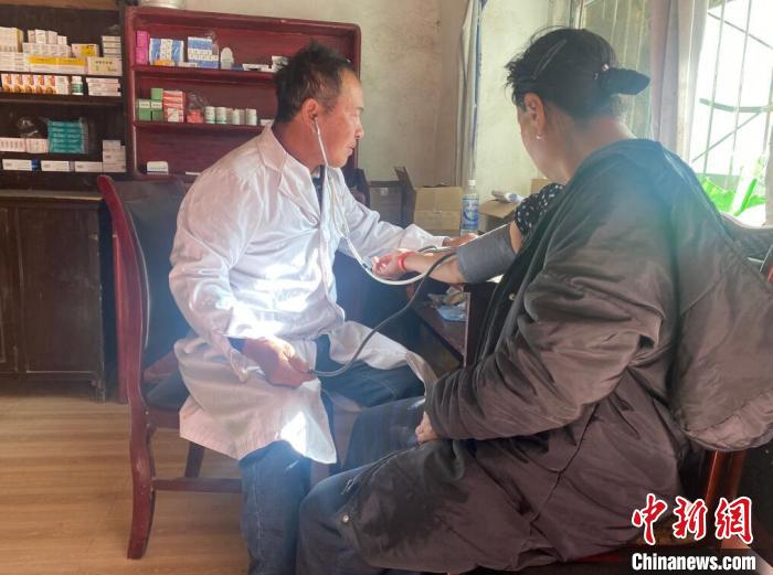 索木滾(左)為村民看病?！∪捞量h委宣傳部供圖
