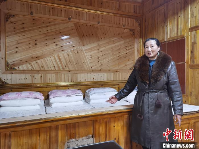 圖為德吉村村民鬧尖措介紹自家農(nóng)家樂?！∑钤鲚?攝