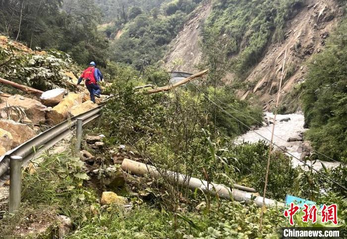 電力搶險人員快速通過危險路段，旁邊是受損的電力線路 四川電力供圖