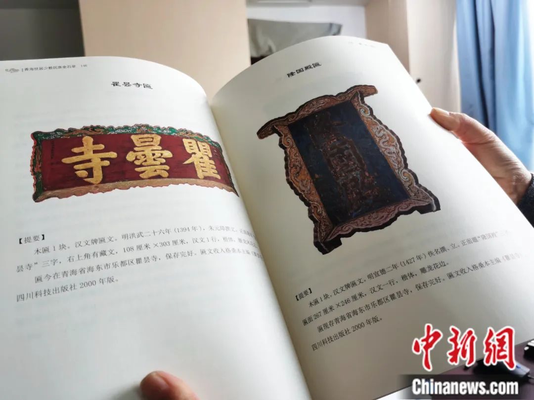 古籍保護(hù)人員展示介紹明代朱元璋撰寫的青海瞿曇寺匾(左)的出版書籍。張?zhí)砀?攝