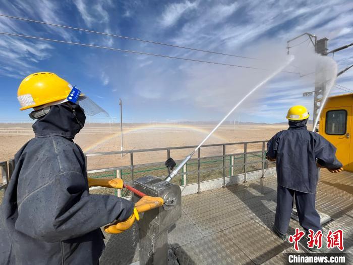圖為水炮手操作高壓水槍對(duì)絕緣子進(jìn)行清洗。　高啟宏 攝