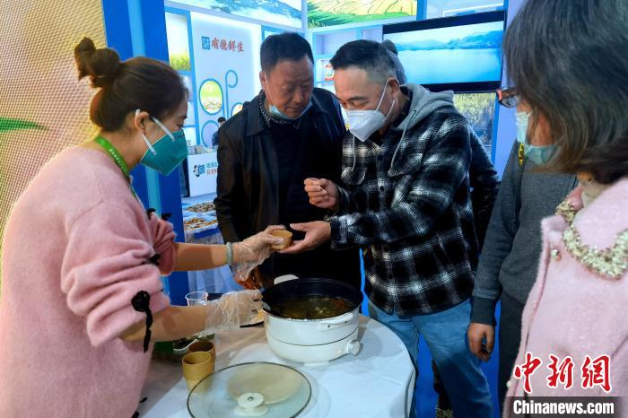 圖為杭州市民品嘗茶卡羊肉。　李雋 攝