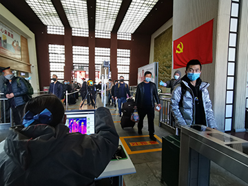 拉薩火車站工作人員對出站旅客進行紅外線測溫。趙越拍攝.jpg
