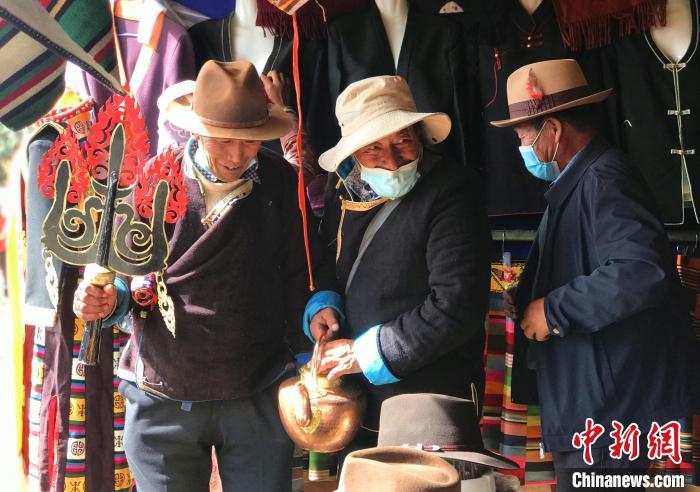 圖為三位藏族老人在集市上聊天交談?！∪轿木?攝