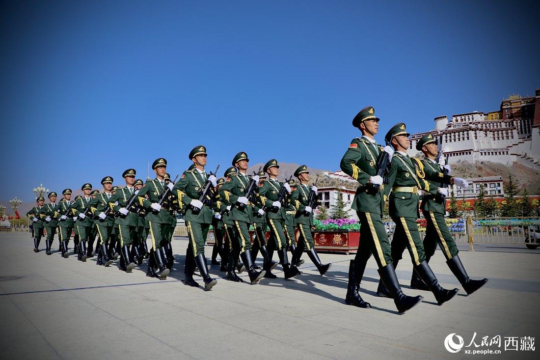 國旗護衛(wèi)隊隊員緊握鋼槍，踏著威武雄壯的步伐，走向國旗臺。人民網(wǎng) 次仁羅布攝