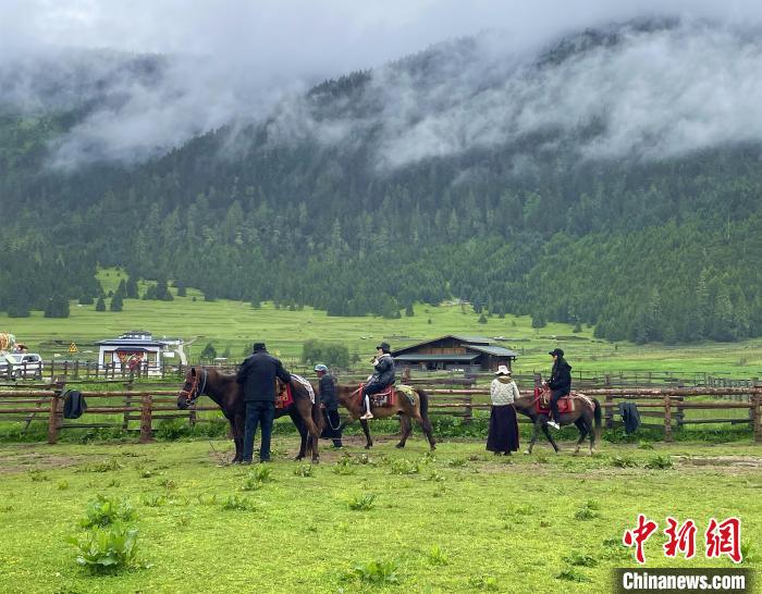 6月10日，游客在魯朗小鎮(zhèn)高山牧場景區(qū)體驗騎馬?！∪轿木?攝