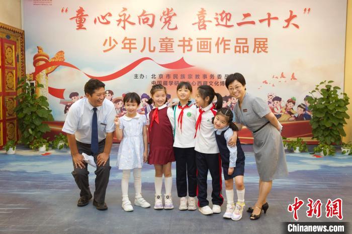 圖為與會嘉賓與入選畫作的“小作者”們在展覽上合影?！≈袊貙W(xué)研究中心供圖