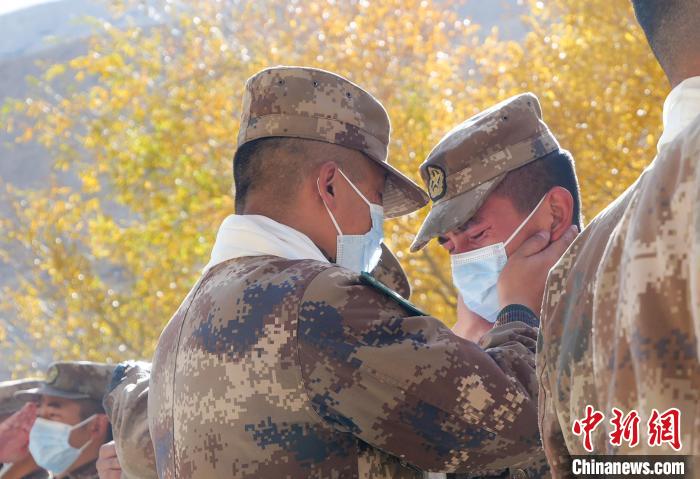 圖為什布奇邊防連退伍老兵與戰(zhàn)友相擁而泣，依依惜別?！⌒觳?攝