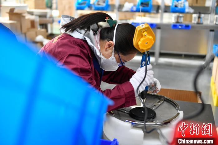 圖為工人正在組裝炊具?！∝暩聛硭?攝