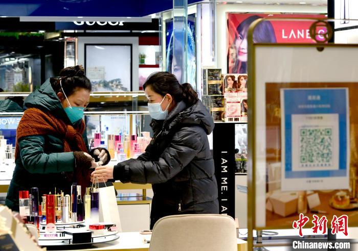 12月7日，拉薩，市民掃碼進(jìn)入拉薩百貨大樓選購護(hù)膚品。　李林 攝
