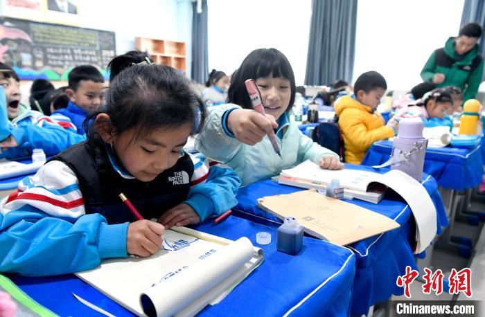 3月14日，西藏拉薩市第一小學(xué)一年級(jí)六班學(xué)生白瑪朗珍(圖左)在藏語(yǔ)文課上書寫藏文?！±盍?攝