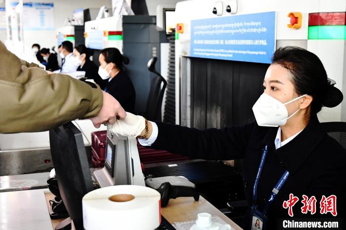 圖為機(jī)場工作人員為旅客辦理行李托運(yùn)?！≈芎?攝