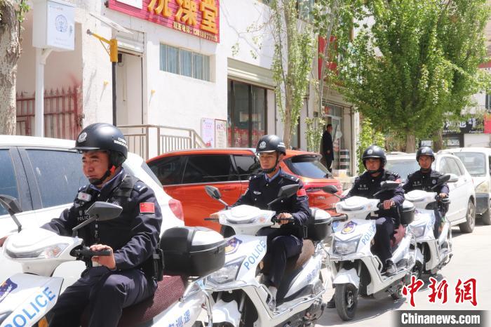 民警騎著電瓶車在轄區(qū)巡邏走訪。　黃創(chuàng)偉 攝